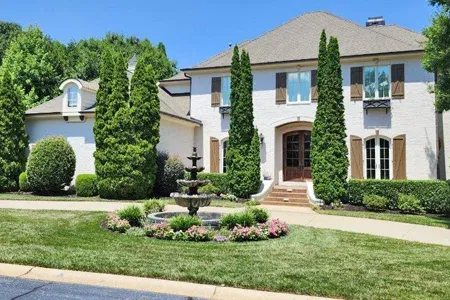 house with healthy trees and shrubs